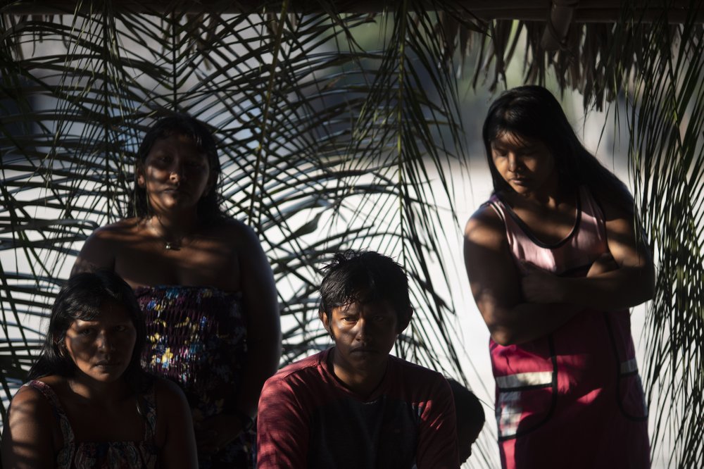 In this Aug. 27, 2019 photo, members of the Kayapo indigenous group attend a meeting to discuss community issues in their village Bau, located on Kayapo indigenous territory in Altamira in Brazil’s Amazon. About 98% of all Brazil’s indigenous lands lie within the Amazon. “Just outside, our reserve is being heavily deforested. It’s being badly destroyed,” a Kayapo leader said. (AP Photo/Leo Correa)