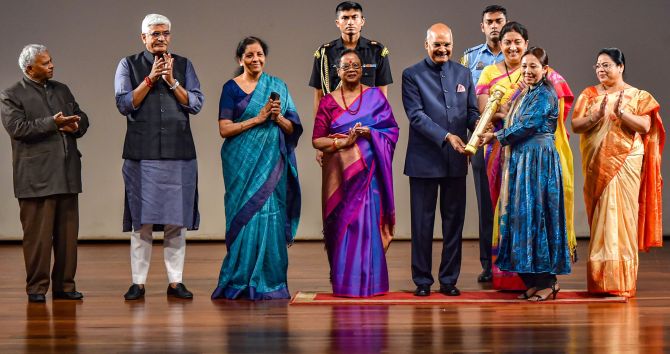Entrepreneur Nilza Wangmo  receives 'Nari Shakti Puraskar 2019' on International Women's Day from President Ram Nath Kovind as First Lady Savita Kovind, Union Ministers Smriti Irani and Nirmala Sitharaman look on, at Rashtrapati Bhavan Cultural Center in New Delhi, Sunday, March 8, 2020. Hailing from Leh district of Ladakh, Wangmo is an entrepreneur who is running Alchi Kitchen restaurant. Today, due to her efforts, Ladakhi cuisine is reaching the world. (PTI Photo/Manvender Vashist)