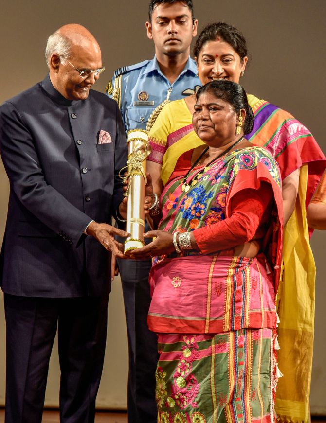 Chami Murmu receives 'Nari Shakti Puraskar 2019' on International Women's Day from President Ram Nath Kovind as Union Minister Smriti Irani looks on, at Rashtrapati Bhavan Cultural Center in New Delhi, Sunday, March 8, 2020. Murmu, a resident of Bhursa village in Jharkhand is known as the 'Lady Tarzan' of Jharkhand for her determination to protect the forests, local wildlife and improve the livelihood of locals. (PTI Photo/Manvender Vashist)
